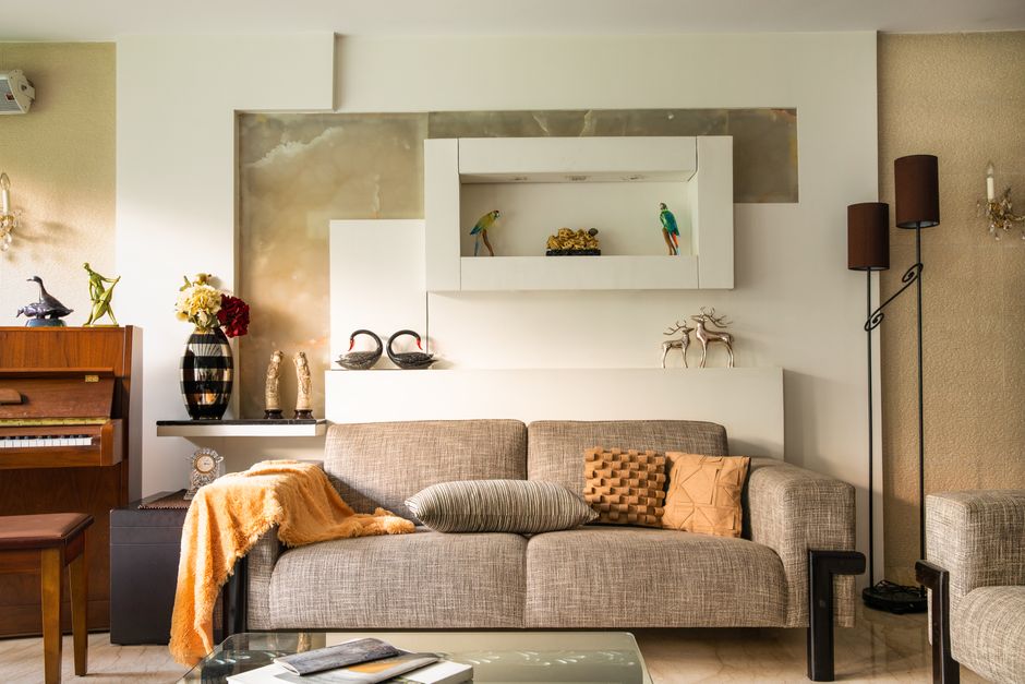 Cozy living room featuring a sofa, decorative items, and a piano, perfect for a stylish home interior.